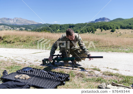 Special operations soldiers team preparing tactical and communication gear for action battle. Long distance sniper team in checking gear for action Special operations soldiers team preparing tactical and communication gear for action battle. Long distance sniper team in checking gear for action 97649344