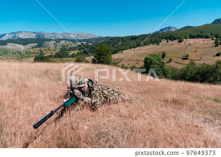 Army soldier holding sniper rifle with scope and aiming in forest. War, army, technology and people concept Army soldier holding sniper rifle with scope and aiming in forest. War, army, technology and people concept 97649373
