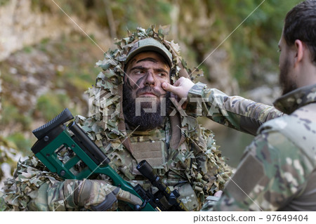 Special operations soldiers team preparing tactical and communication gear for action battle. Long distance sniper team in checking gear for action Special operations soldiers team preparing tactical and communication gear for action battle. Long distance sniper team in checking gear for action 97649404