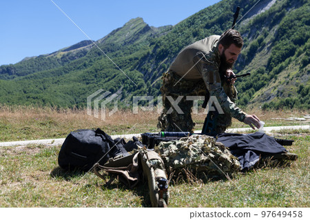 Special operations soldiers team preparing tactical and communication gear for action battle. Long distance sniper team in checking gear for action 97649458