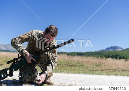 Special operations soldiers team preparing tactical and communication gear for action battle. Long distance sniper team in checking gear for action Special operations soldiers team preparing tactical and communication gear for action battle. Long distance sniper team in checking gear for action 97649520