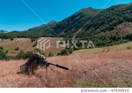 Army soldier holding sniper rifle with scope and aiming in forest. War, army, technology and people concept Army soldier holding sniper rifle with scope and aiming in forest. War, army, technology and people concept 97649918