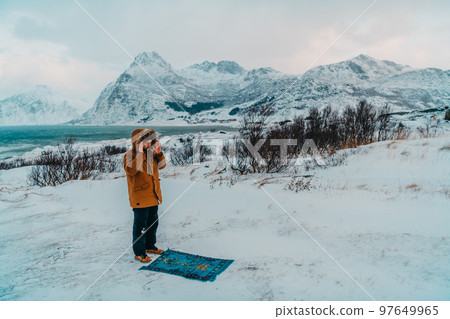 A Muslim traveling through arctic cold regions while performing the Muslim prayer namaz during breaks A Muslim traveling through arctic cold regions while performing the Muslim prayer namaz during breaks 97649965