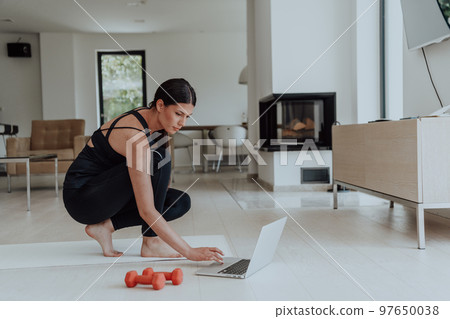 Young Beautiful Female Woman with Trainer via Video Call Conference in Bright Sunny House. Healthy Lifestyle, Wellbeing and Mindfulness Concept. Young Beautiful Female Woman with Trainer via Video Call Conference in Bright Sunny House. Healthy Lifestyle, Wellbeing and Mindfulness Concept. 97650038