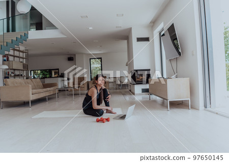 Young Beautiful Female Woman with Trainer via Video Call Conference in Bright Sunny House. Healthy Lifestyle, Wellbeing and Mindfulness Concept. Young Beautiful Female Woman with Trainer via Video Call Conference in Bright Sunny House. Healthy Lifestyle, Wellbeing and Mindfulness Concept. 97650145