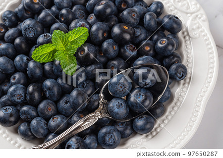 Plate full of sweet blueberries closeup. Ripe juicy blueberries as detox diet ingredient. 97650287