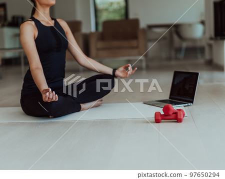 Young Beautiful Female Exercising, Stretching and Practising Yoga with Trainer via Video Call Conference in Bright Sunny House. Healthy Lifestyle, Wellbeing and Mindfulness Concept. Young Beautiful Female Exercising, Stretching and Practising Yoga with Trainer via Video Call Conference in Bright Sunny House. Healthy Lifestyle, Wellbeing and Mindfulness Concept. 97650294