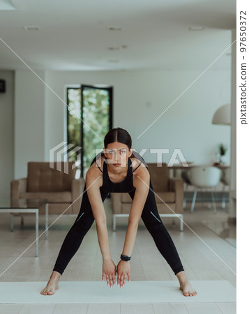 Young Beautiful Female Exercising, Stretching and Practising Yoga with Trainer via Video Call Conference in Bright Sunny House. Healthy Lifestyle, Wellbeing and Mindfulness Concept. Young Beautiful Female Exercising, Stretching and Practising Yoga with Trainer via Video Call Conference in Bright Sunny House. Healthy Lifestyle, Wellbeing and Mindfulness Concept. 97650372