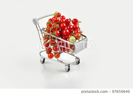 Mini shopping cart full with cherry tomatos on white background 97650640