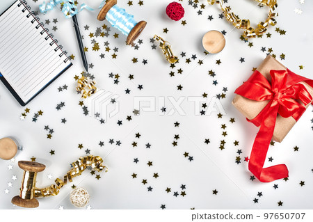 Flat Lay Christmas or Party Background with colored ribbons, decorations, confetti, and wrapping paper. Notepad for Text Flat Lay Christmas or Party Background with colored ribbons, decorations, confetti, and wrapping paper. Notepad for Text 97650707