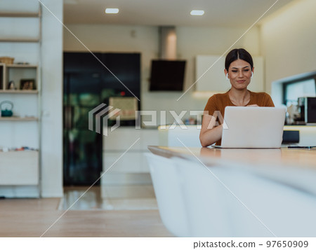 Woman sitting in living room using laptop look at cam talk by video call with business friend relatives, head shot. Job interview answering questions. Woman sitting in living room using laptop look at cam talk by video call with business friend relatives, head shot. Job interview answering questions. 97650909