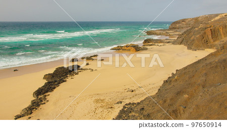 Empty sand Cofete beach with endless horizon. Volcanic hills in the background and Atlantic Ocean. Fuerteventura, Canary Islands, Spain. Playa de Cofete. 97650914