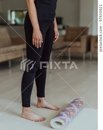 A woman in sports clothes resting after a hard online training session 97650921