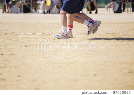 The feet of a three-legged team at an athletic meet 97650985