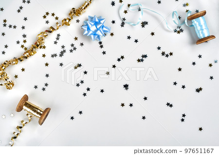 Delicate wavy ribbons and metallic star shaped confetti isolated on white background. Christmas holidays decoration concept. Delicate wavy ribbons and metallic star shaped confetti isolated on white background. Christmas holidays decoration concept. 97651167