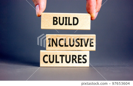 Build inclusive cultures symbol. Concept words Build inclusive cultures on wooden blocks. Businessman hand. Beautiful grey background. Business build inclusive cultures concept. Copy space. Build inclusive cultures symbol. Concept words Build inclusive cultures on wooden blocks. Businessman hand. Beautiful grey background. Business build inclusive cultures concept. Copy space. 97653604