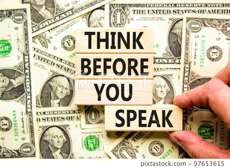 Think before you speak symbol. Concept words Think before you speak on wooden cubes. Beautiful background from dollar bills. Businessman hand. Business think before you speak concept. Copy space. 97653615