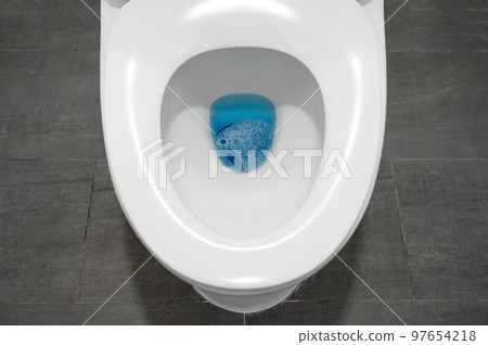 White toilet flushing bowl with open lid on ceramic grey in the bathroom 97654218