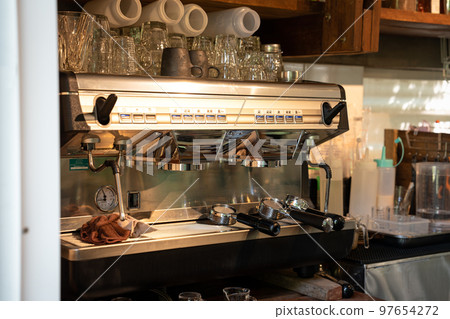Automatic coffee machine with bottomless portafilter and glass in coffee shop 97654272