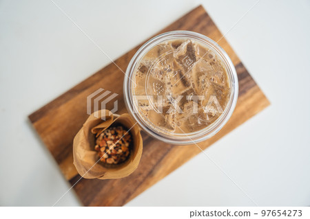 Iced Latte coffee in plastic glass and dessert chocolate ball on wooden tray 97654273