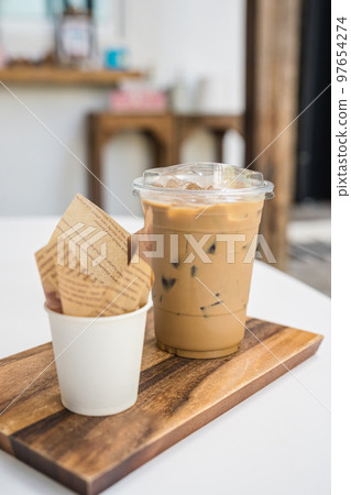 Iced Latte coffee in plastic glass and dessert chocolate ball on wooden tray 97654274