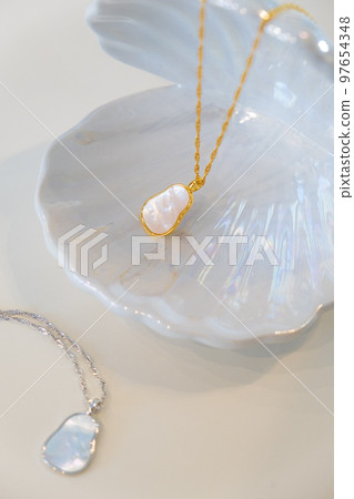 Golden and silver chain pearl necklaces on white Golden and silver chain pearl necklaces on white 97654348