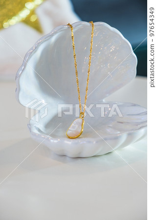Golden chain pearl necklace on white Golden chain pearl necklace on white 97654349