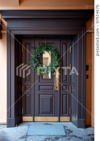 The entrance door is decorated with a Christmas wreath 97654676