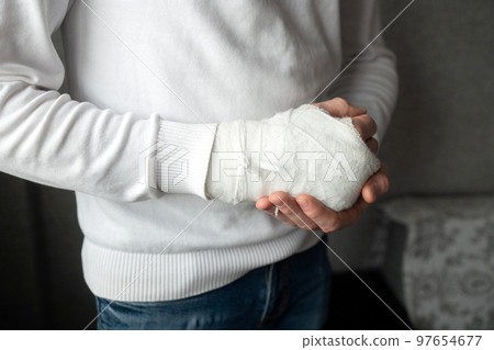 A man's broken arm in a cast A man's broken arm in a cast 97654677