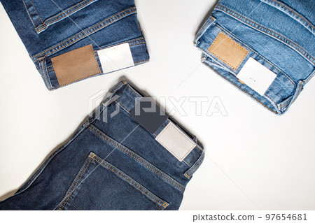 Three pairs of new denim trousers on a white background. Three pairs of new denim trousers on a white background. 97654681