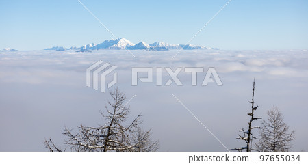 Winter mountains covered with snow landscape over clouds 97655034