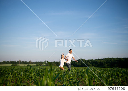 Cute boy in a cornfield with dad launching a plane 97655208