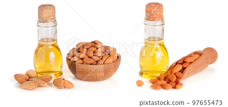 Bottle of almond oil and almonds in a wooden bowl isolated on white background Bottle of almond oil and almonds in a wooden bowl isolated on white background 97655473