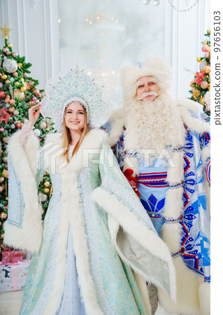 a Father Frost and Snow Maiden in blue costume in the room with christmas trees a Father Frost and Snow Maiden in blue costume in the room with christmas trees 97656103
