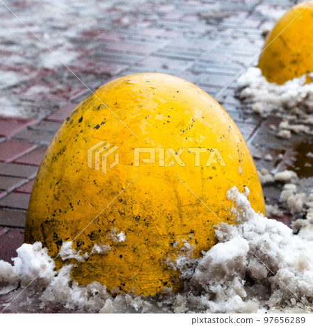 Concrete parking bollards on the road. 97656289