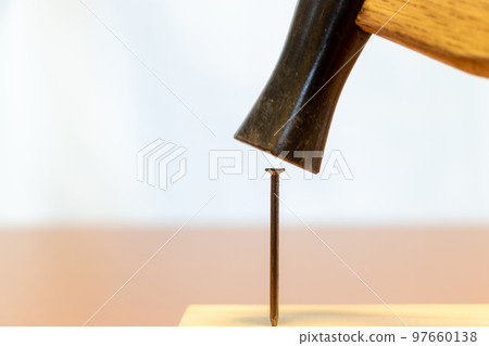 hammer an iron nail into wood hammer an iron nail into wood 97660138