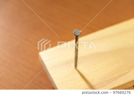 nail nailed in a piece of wood 97660276