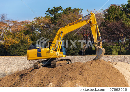 Hydraulic excavator working on a pile of sand Hydraulic excavator working on a pile of sand 97662926