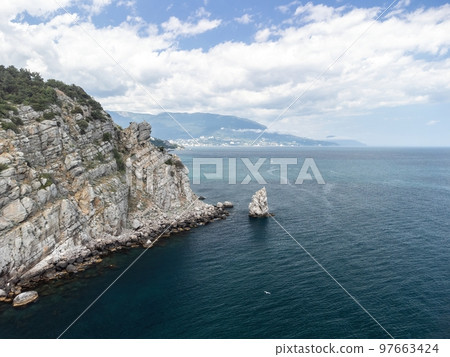 aerial photo of rock Parus Sail and Ayu-Dag Bear Mountain and near Gaspra, Yalta, Crimea at bright sunny day over the Black sea. Rock Parus in Gaspra near Swallow's nest in Crimea. aerial photo of rock Parus Sail and Ayu-Dag Bear Mountain and near Gaspra, Yalta, Crimea at bright sunny day over the Black sea. Rock Parus in Gaspra near Swallow's nest in Crimea. 97663424