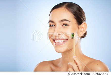 Face portrait, dental and woman with toothbrush in studio isolated on a blue background. Oral wellness, veneers and happy female model holding product for brushing teeth, cleaning and oral hygiene. 97663567