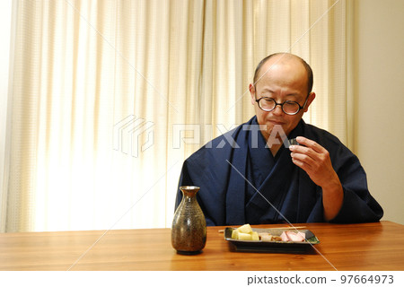 A man who enjoys drinking in a kimono A man who enjoys drinking in a kimono 97664973