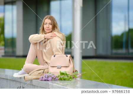 Cute senior woman in fleece jump suit sitting outdoor Cute senior woman in fleece jump suit sitting outdoor 97666158