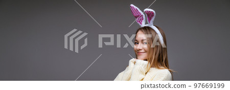 young woman in bunny ears on a gray background 97669199