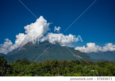 View of Doi Luang Chiang Dao, the third highest mountain in Thailand, seen with dramatic clouds and colorful sky with camping tents in foreground View of Doi Luang Chiang Dao, the third highest mountain in Thailand, seen with dramatic clouds and colorful sky with camping tents in foreground 97669671