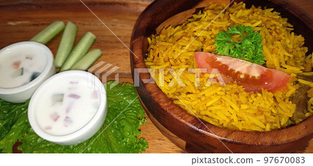 Rice lamb biryani pilaf with lamb or mutton meat and vegetables cucumber  along with yoghurt in a very nice american restaurant 97670083
