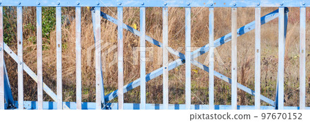 一個雜草叢生的停車場的滑動柵欄門 97670152