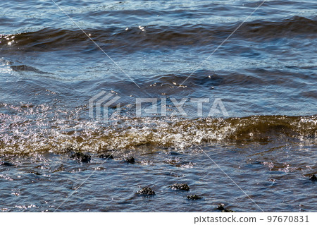 Waves crashing against the shore with a splash Waves crashing against the shore with a splash 97670831