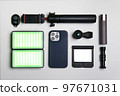Equipment for shooting video on a smartphone. Microphone, LED lamp, tripod, lens smartphone are on a white table 97671031