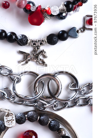 chain and bracelets with black  semipreciouse stones with natural lava, shungite,  hematite,  around white background.  top view 97673936