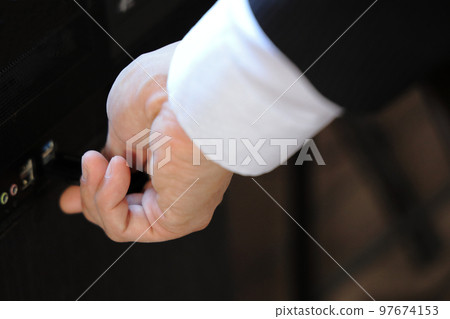 A man's hand inserting and removing a USB memory A man's hand inserting and removing a USB memory 97674153